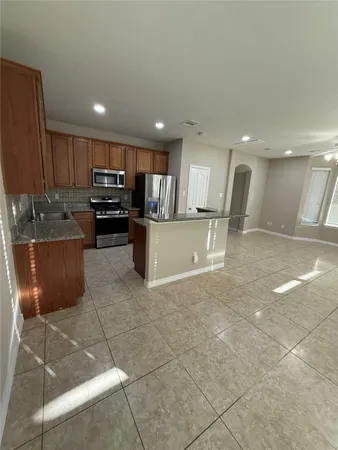 a kitchen with stainless steel appliances granite countertop a refrigerator and a sink