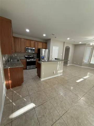 a kitchen with stainless steel appliances granite countertop a refrigerator and a sink
