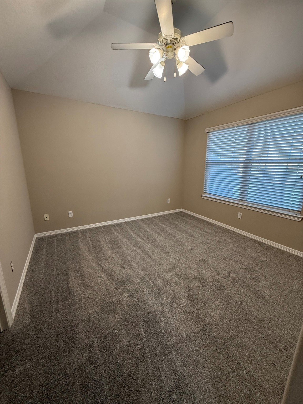 9224 Rodney Ray Boulevard, Unit 1 Houston, TX 77040 - Photo 4 of 11 an empty room with a chandelier fan and windows