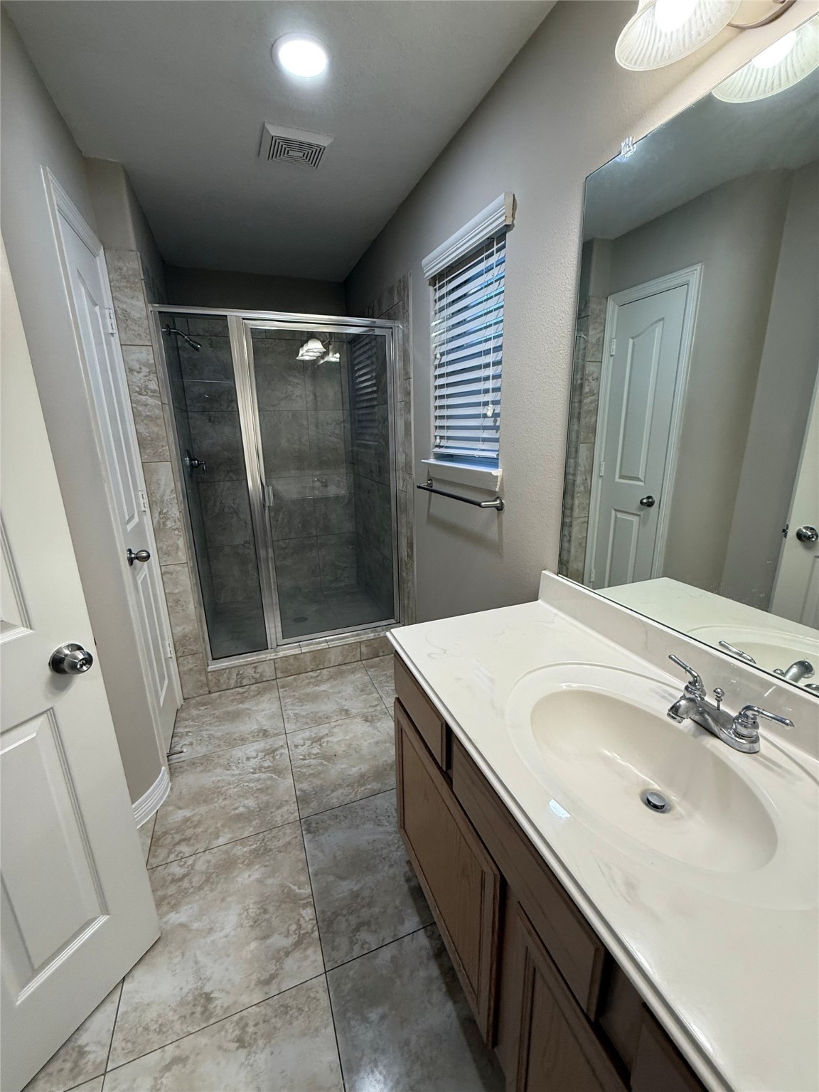 9224 Rodney Ray Boulevard, Unit 1 Houston, TX 77040 - Photo 6 of 11 a bathroom with a sink a mirror and a shower