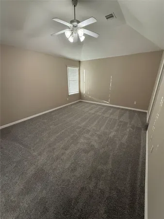 en empty room with windows and ceiling fan