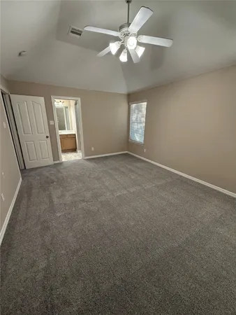 an empty room with windows and fan