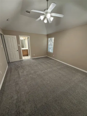 an empty room with windows and fan