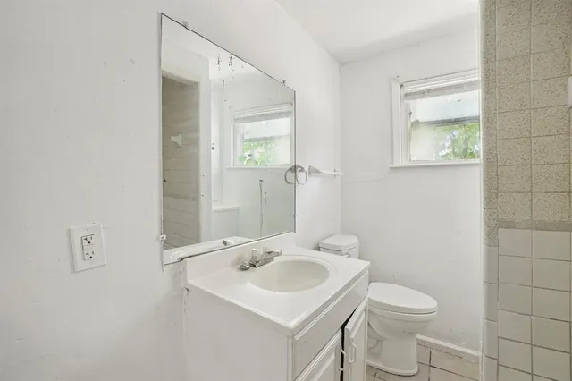 a bathroom with a sink toilet and mirror