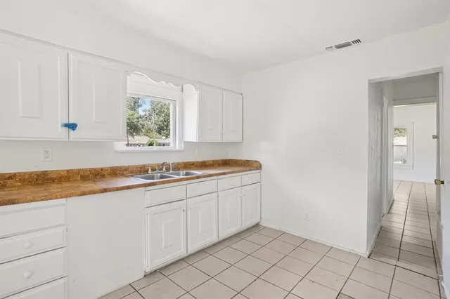 a kitchen with granite countertop white cabinets and sink