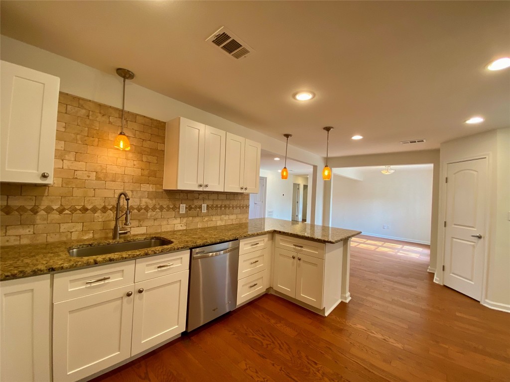 2003 Patton Lane Austin, TX 78723 - Photo 11 of 38 Kitchen featuring a peninsula, white cabinetry, dark stone countertops, hanging light fixtures, and recessed lighting