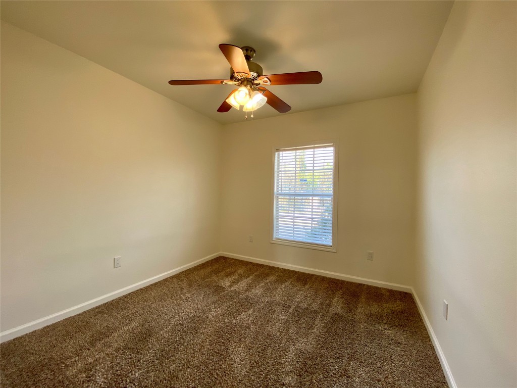 2003 Patton Lane Austin, TX 78723 - Photo 21 of 38 Guest Bedroom 1 with dark carpet and a ceiling fan