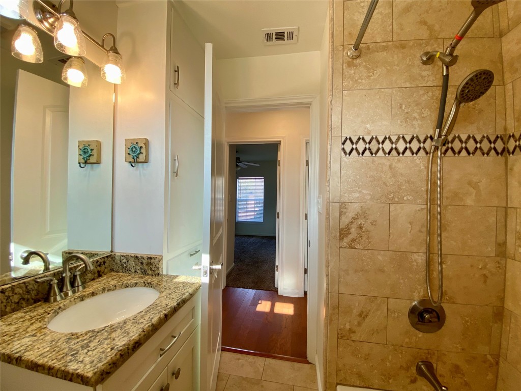 2003 Patton Lane Austin, TX 78723 - Photo 26 of 38 Guest Bathroom featuring shower combination, vanity, and light tile patterned floors