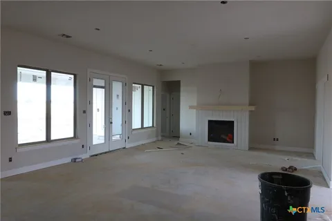 a view of an empty room with a fireplace and a window