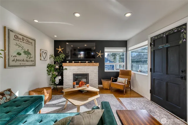 a living room with furniture a flat screen tv and a fireplace