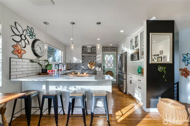 a kitchen with stainless steel appliances granite countertop a table chairs and a chandelier