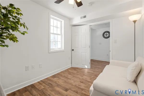 a spacious bedroom with a bed and a chandelier fan