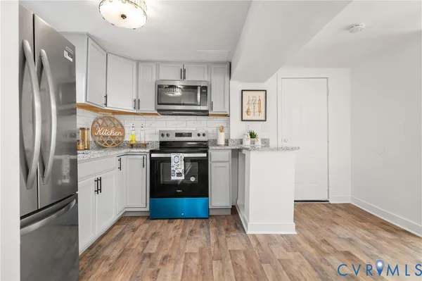 a kitchen with white cabinets and stainless steel appliances