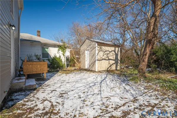 a backyard of a house with barbeque oven table and chairs