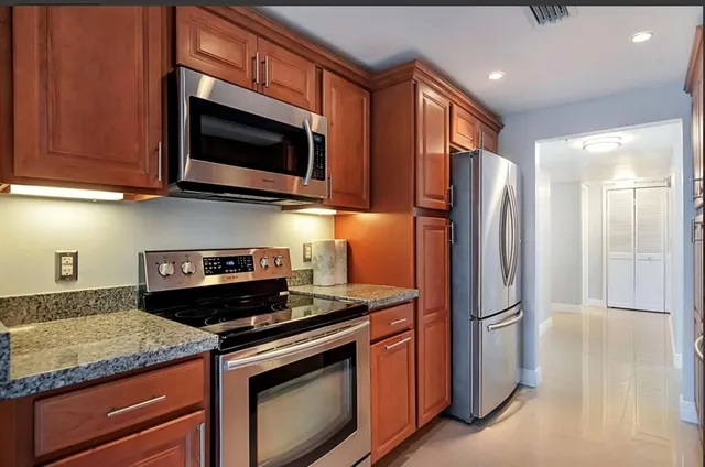 a kitchen with stainless steel appliances granite countertop a stove microwave and refrigerator