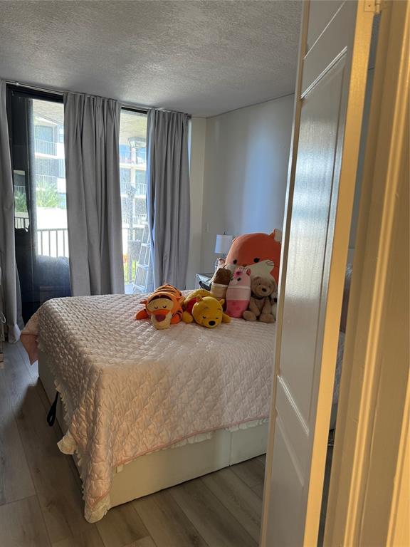 859 Jeffery Street, Unit 214 Boca Raton, FL 33487 - Photo 24 of 32 a bedroom with a bed and wooden floor