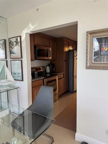 a kitchen with stainless steel appliances granite countertop a refrigerator and a stove top oven