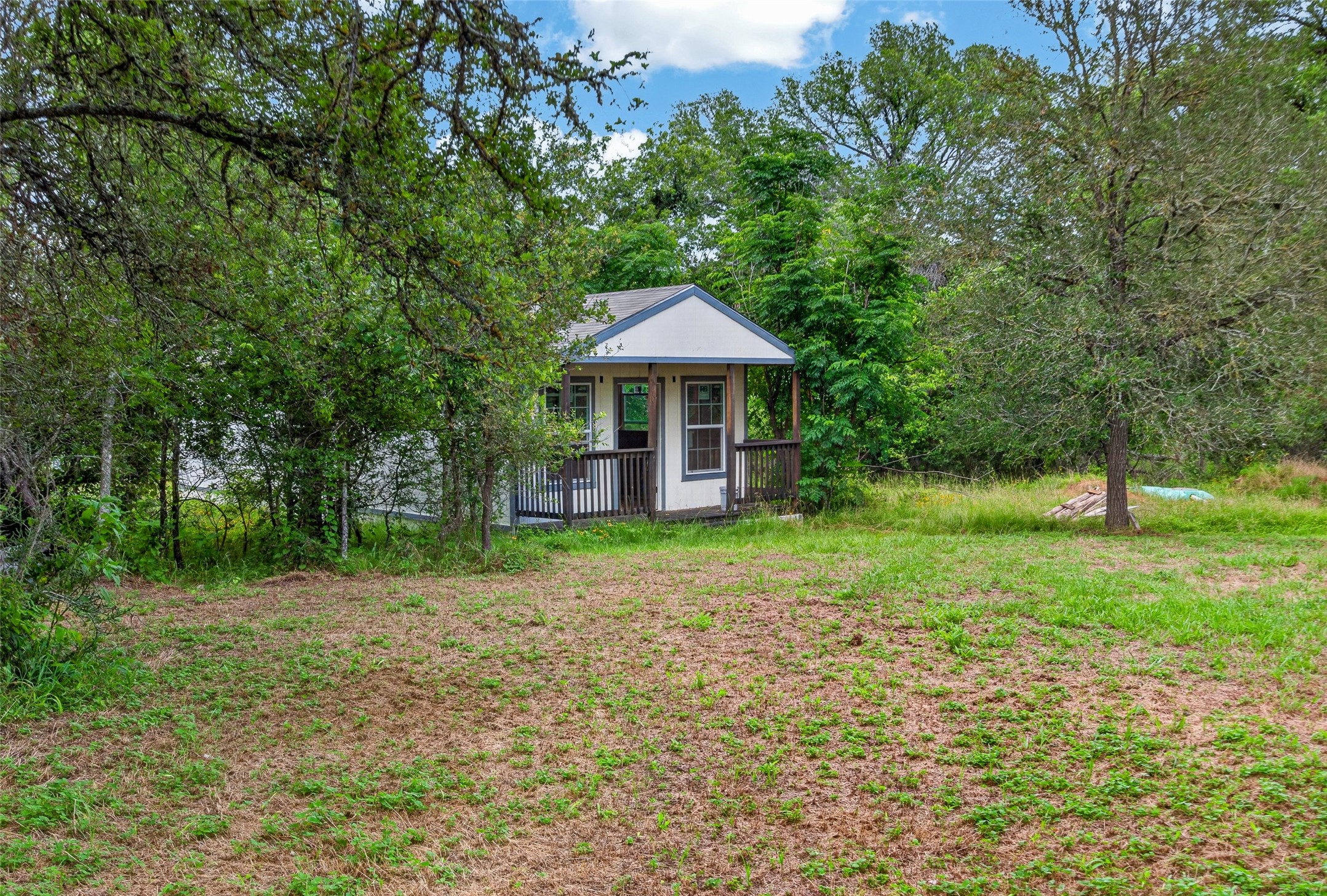 266 Beaver Road Elgin, TX 78621 - Photo 7 of 40 A charming, petite unfinished cottage offers a private retreat nestled amongst mature shade trees.