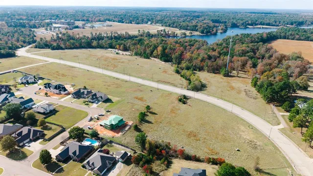 an aerial view of a house with a yard and lake view