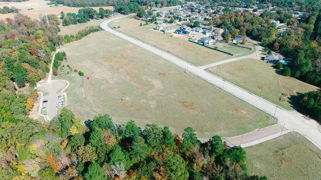an aerial view of a house with a yard and lake view