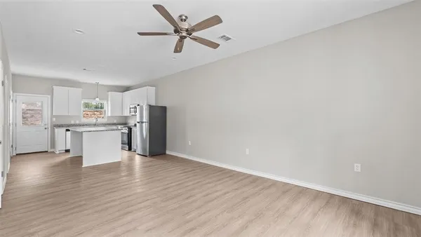 a view of a kitchen with an empty space and wooden floor