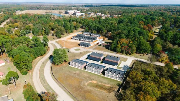 an aerial view of a house with a yard and lake view