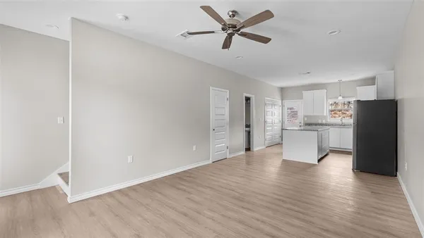 a view of a kitchen with a refrigerator and wooden floor