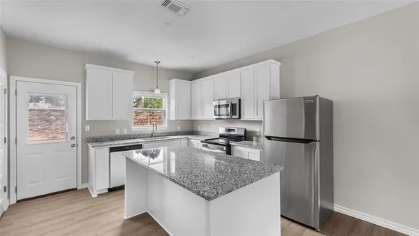 a kitchen with stainless steel appliances granite countertop a sink stove and refrigerator