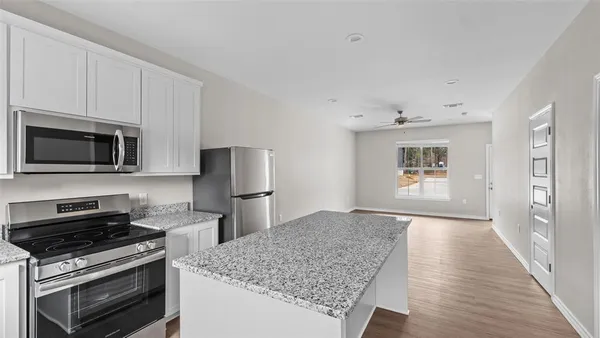 a kitchen with stainless steel appliances granite countertop a stove microwave and sink