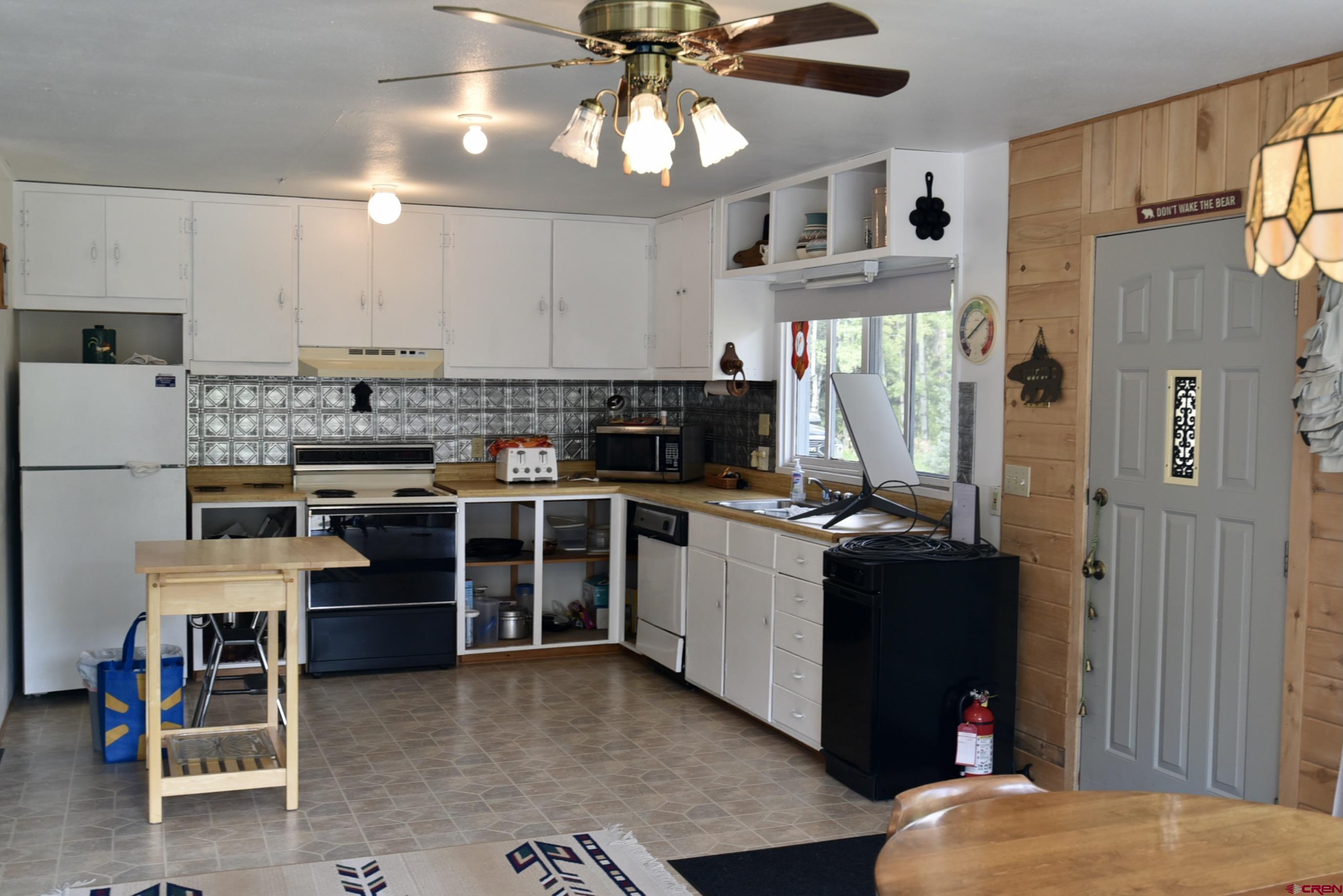 704 Hampton Road Montrose, CO 81220 - Photo 6 of 45 a kitchen with stainless steel appliances kitchen island granite countertop a refrigerator and a stove top oven