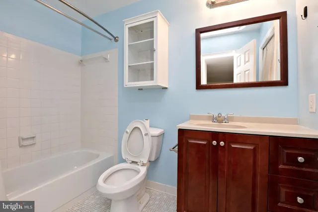a bathroom with a toilet a sink a tub and mirror