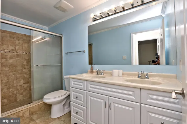 a bathroom with a sink a toilet a mirror and shower