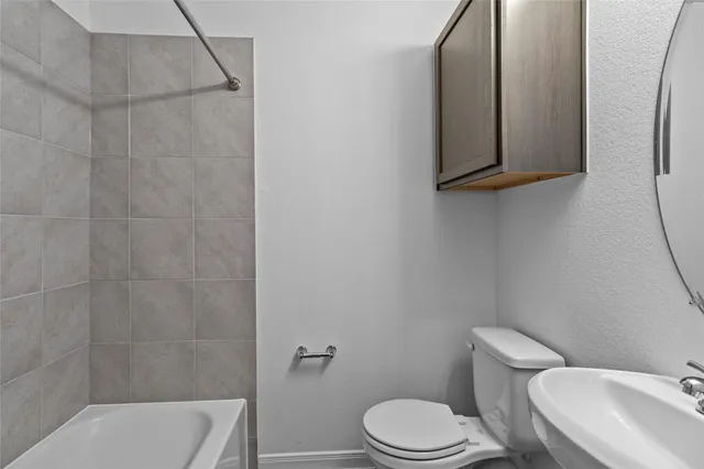 a white toilet sitting next to a bathroom sink and vanity