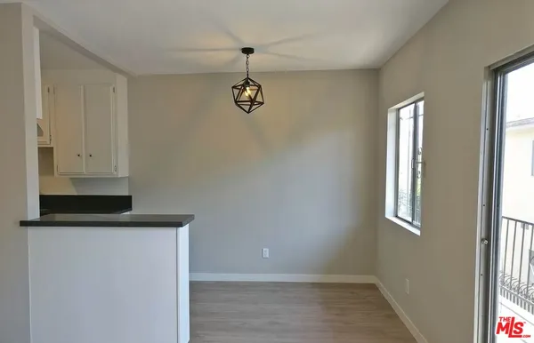a view of hallway with window and wooden floor