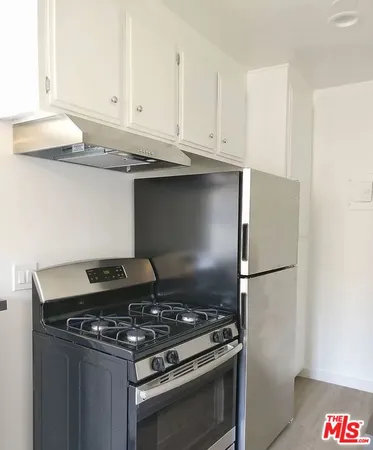 a stove top oven sitting inside of a kitchen