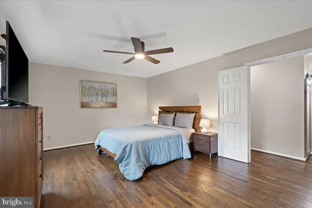 a view of a patio with table and chairs and a barbeque with potted plants and large trees