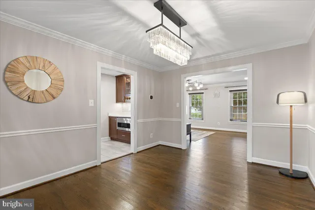 a view of an empty room with a window and a kitchen
