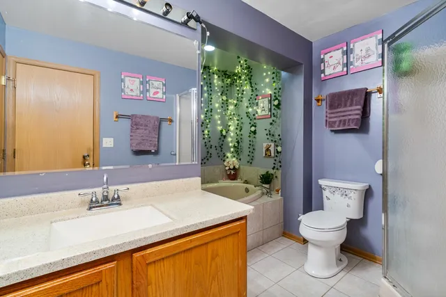 a bathroom with a granite countertop toilet sink and mirror