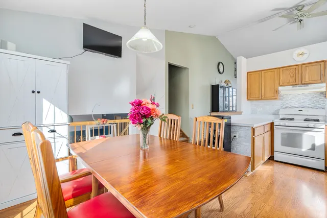 a kitchen with stainless steel appliances kitchen island granite countertop a table chairs and a stove