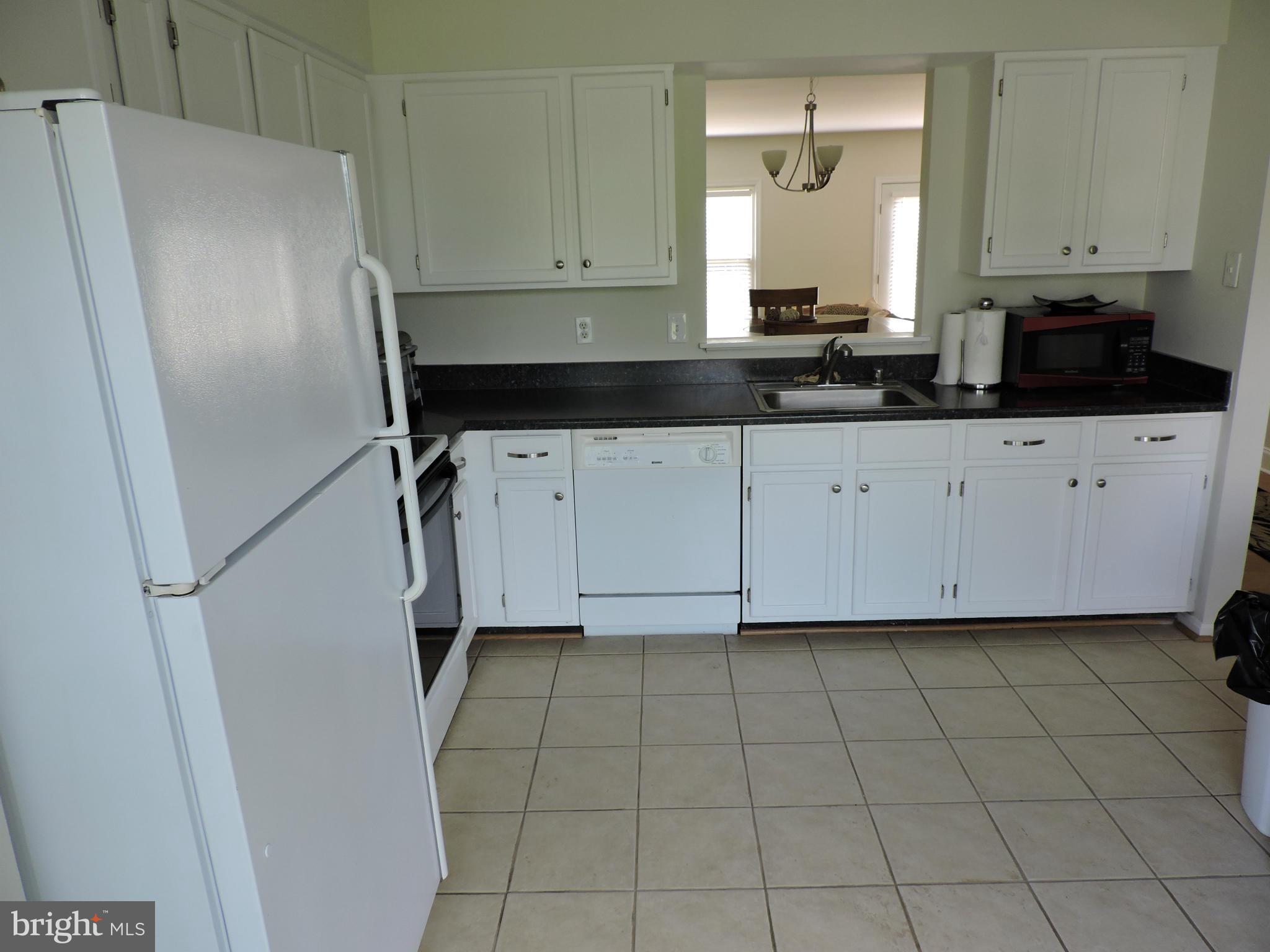 331 Davis Avenue Southwest Leesburg, VA 20175 - Photo 6 of 29 a kitchen with a refrigerator a stove a sink and a window