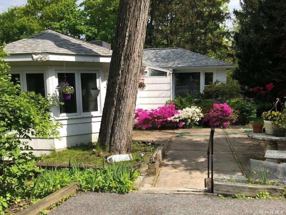 a front view of a house with flower plants