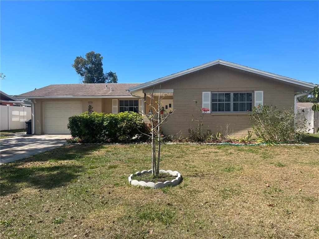 10327 Orchid Drive Port Richey, FL 34668 - Photo 1 of 1 a front view of a house with a yard