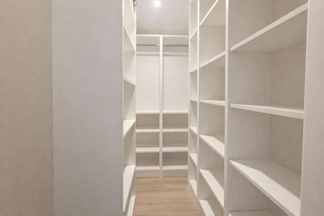 a view of walk in closet with empty racks