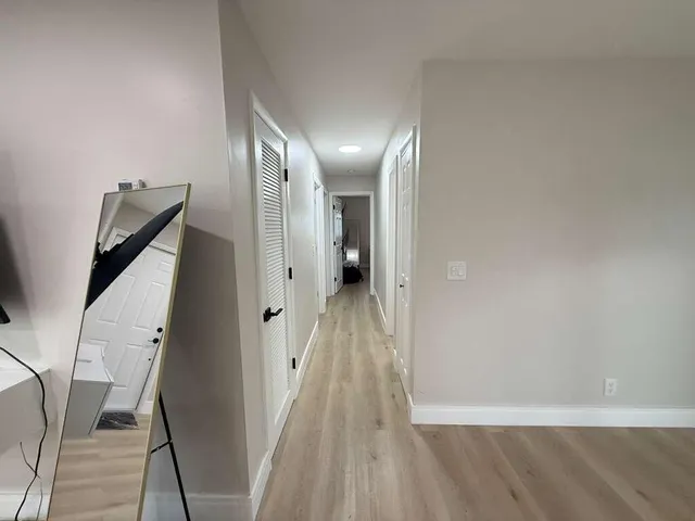 a view of a hallway with wooden floor