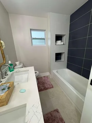 a bathroom with a tub sink and mirror