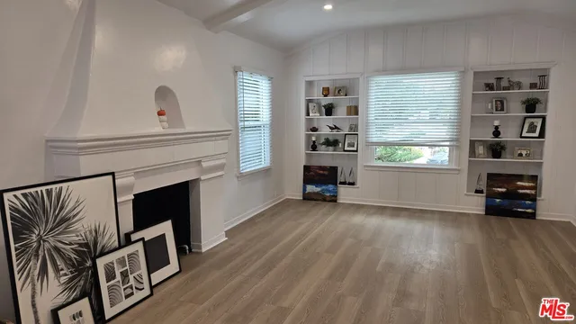 a view of an empty room with a window and fireplace