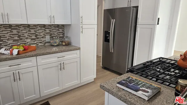 a kitchen with stainless steel appliances granite countertop a refrigerator and a stove