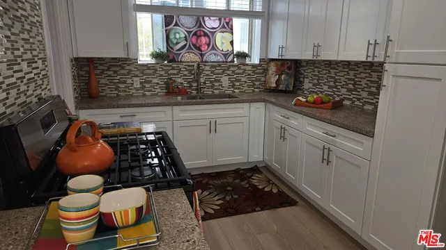 a kitchen with stainless steel appliances granite countertop a stove and cabinets