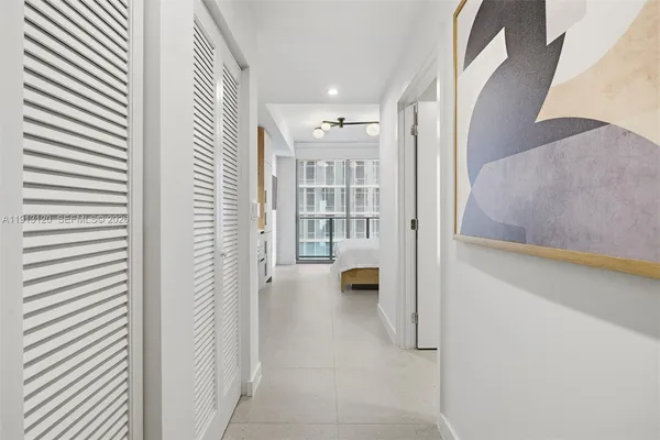 a view of a hallway with wooden floor and a living room