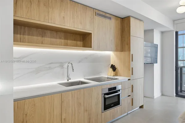 a kitchen with stainless steel appliances granite countertop a sink and a microwave